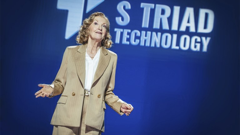 Susan Triad on stage in a beige suit in Doctor Who episode "The Legend of Ruby Sunday"