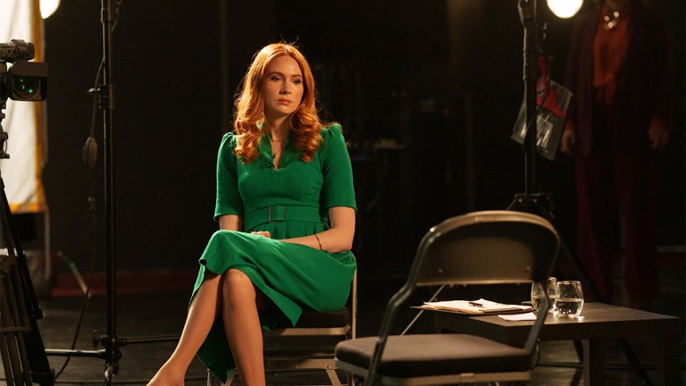 Karen Gillen as Madeline, sitting in a studio, wearing a green dress in "Douglas is Cancelled"