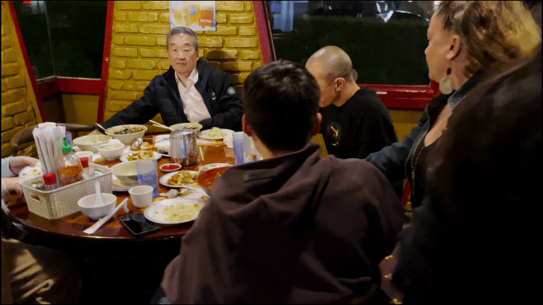 7M's Robert Shinn getting served papers in a hot pot restaurant in the Netflix docuseries Dancing for the Devil: The 7M TikTok Cult