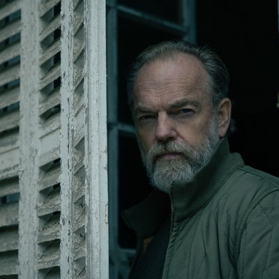 Hugo Weaving standing by a window shutter in Slow Horses season 4